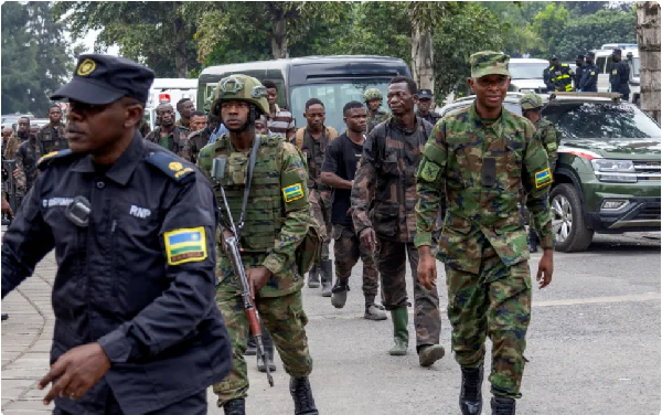Rwandan security officers escort members of the armed forces of the DRC