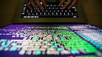 A file photo of someone trying to hack a computer system