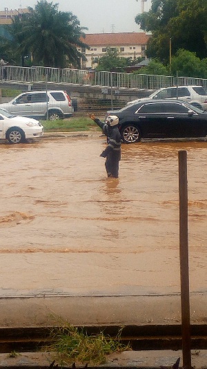 The policeman on duty directing vehicles in the flood