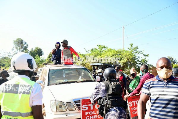 NUP presidential candidate Robert Kyagulanyi, alias Bobi Wine (atop car, right), engages police