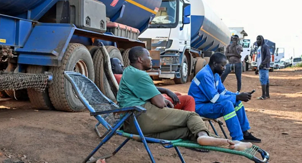 These tanker drivers on the Ivory Coast-Mali border wait by their vehicles for a military escort