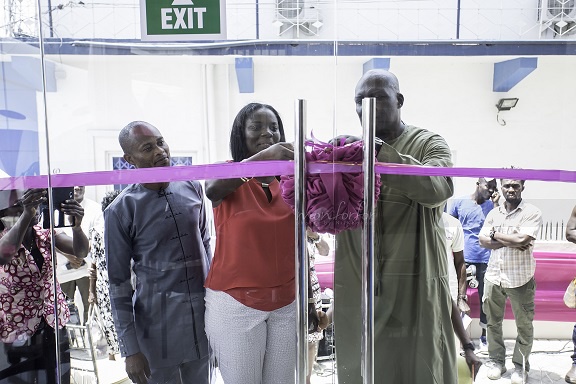 Amanda assisting Mr Thomson cut the ribbon for the official opening while Pastor Adjatey looks on