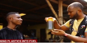 Emmanuel Nimo (Left) interacting with the reporter holding a bottle of diesel extracted from plastic