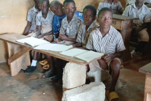 Pupils of Adjoum M/A Basic School use cement blocks as classroom furniture