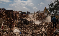 Excavator helps search for people trapped under debris after a landfill collapsed in Kampala