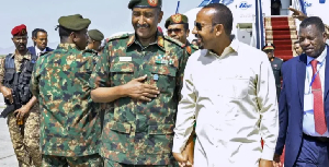 Ethiopian Prime Minister Abiy Ahmed (R) walks with Sudan’s army chief General Abdel Fattah al-Burhan