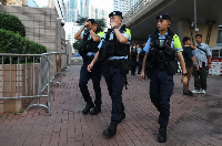 Police officers patrol outside the West Kowloon Law Courts Building in Hong Kong