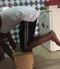A picture of a man demonstrating 'the kitchen stool challenge'