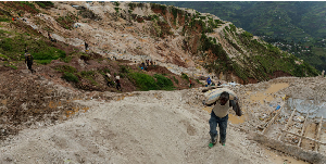 A labourer carries a sack of ore at the Rubaya coltan mine, a town controlled by M23 rebels