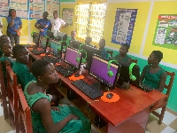 Some students of Matse Basic School sittee behind some of the computers in the new lab