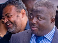 Mustapha Gbande in suit and blue stripped shirt