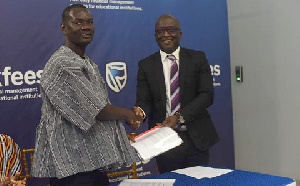Nana Benneh (left) exchange documents with Eric Appiah