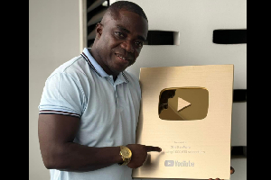 Shatta Wale's Manager, Sammy Flex holding up the plaque