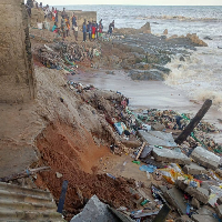 Some people stand at the shore where the destruction occurred