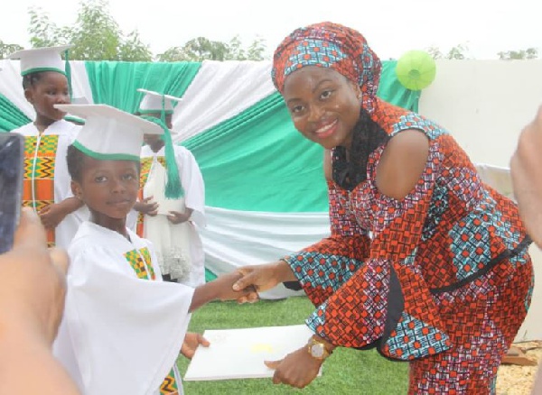 Mrs. Kyei-Mensah presenting a certificate to one of the seven graduates