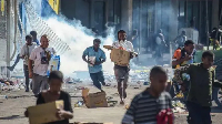 Demonstrators flee tear gas during a pro-Ousmane Sonko protest in Dakar