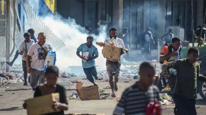 Demonstrators flee tear gas during a pro-Ousmane Sonko protest in Dakar