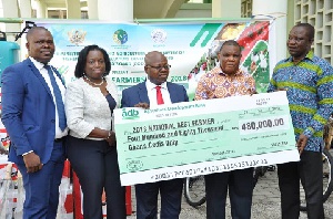 The MD of ADB, Dr. Kofi Mensah [M] presenting a dummy cheque to the Ministry of Food and Agriculture