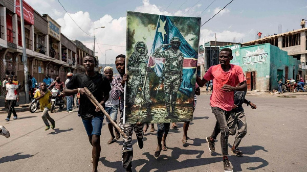 Demonstrators carry a poster honouring the DRC's armed forces during a protest in Goma