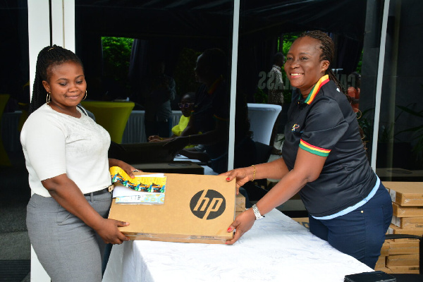 MTN Bright Scholarship beneficiary receiving a laptop and airtime from Cynthia Mills of the MTN Gh.
