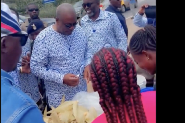 President Mahama is seen buying from the roadside boiled corn seller