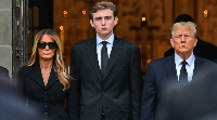 Former US President Donald  Trump (R)  with his wife Melania Trump (L) their son Barron Trump (C)