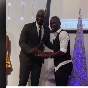 Tony Baffoe presenting Badu's award to him