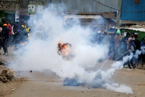 A tear gas canister lobbed by riot police explodes as some Kenyans protests against tax hikes