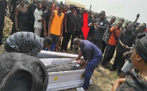 The corpse was carried by the mortuary man and his friend in the middle of the burial process