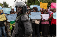 M23 police stands guard as protesters march against insecurity and violence against civilians