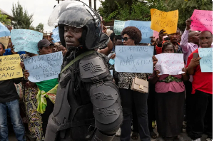 M23 police stands guard as protesters march against insecurity and violence against civilians