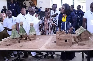 Nana Oye Lithur inspects a miniature community with some dignitaries