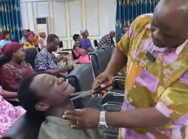 Screenshot from video showing prophet Naakwaa shave off church member's beard