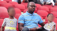 The dad watching football with his kids