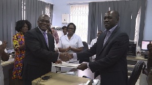 Eric Opoku (R) presenting the handing over notes of the donation to Dr. Anaab-Bisi