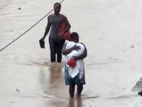 The woman carried her baby through the flood