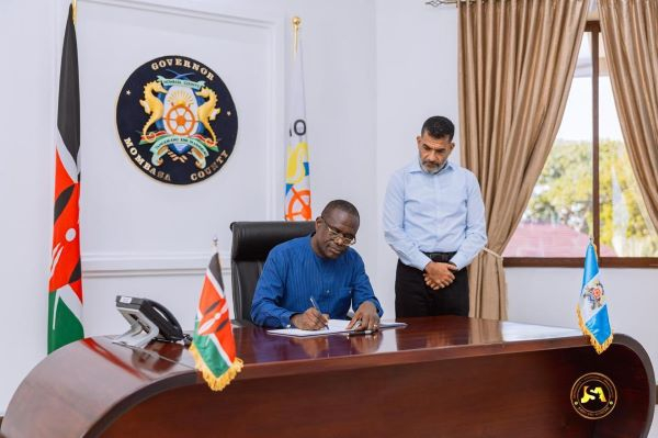 Dr Joseph Siaw Agyepong (seated) signing an agreement in Kenya