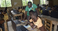 A tutor taking the pupils through computer lessons