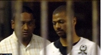 A police officer leads Thabo Bester (right) out of the holding cells at the Durban Magistrates Court