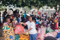 Ruth Baidoo of AmaCares [R] presenting some items to residents