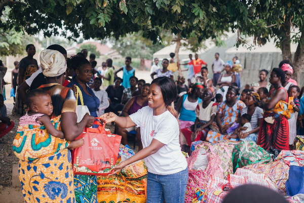 Ruth Baidoo of AmaCares [R] presenting some items to residents