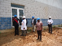 Hon. Ayariga (standing far left)  in a discussion with ACARP officials at the site