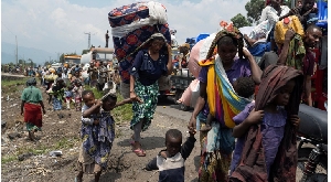 People carry their belongings as they flee from their villages around Sake in Masisi territory