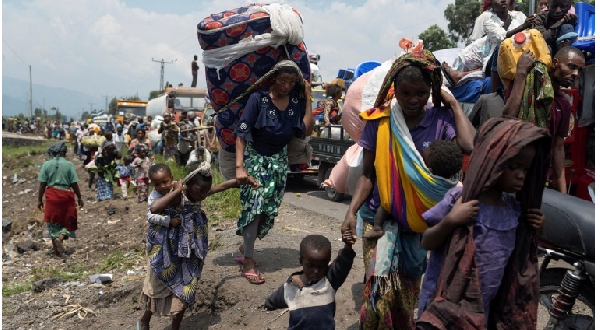 People carry their belongings as they flee from their villages around Sake in Masisi territory