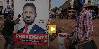 A supporter of Bobi Wine holds onto a campaign poster in Kampala, Uganda, Tuesday, Jan. 13, 2026