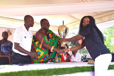 Asantehene Otumfuo Osei Tutu II giving the trophy to one of the winners