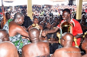 Captain Amos Frimpong presents the trophy to the Asantehene.