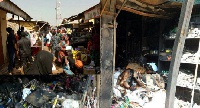 Some market women removing their wares, while others look on