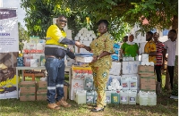 Samuel Noi, Process Manager at Ahafo South Mine presents items to the District Health Director