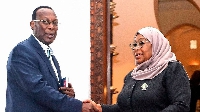 Tanzania's President Samia Suluhu Hassan (R) shakes hands with the opposition leader Freeman Mbowe